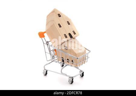 2 Holzhausmodelle im Warenkorb isolieren auf weißem Hintergrund. Stockfoto
