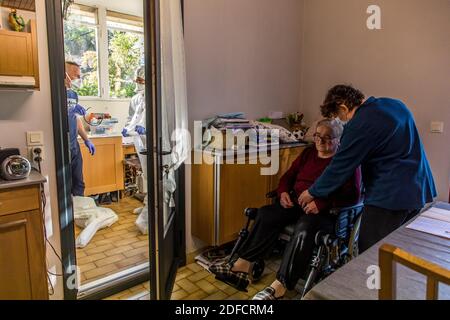 DIE BETREUUNG VON FERNANDA, EINER ÄLTEREN FRAU IN IHREM ZUHAUSE, DIE COVID 19 ERHALTEN SOLL, DURCH EIN TEAM FREIBERUFLICHER KRANKENSCHWESTERN AUS DER ABTEILUNG BIEN VIEILLIR (WACHSENDER BRUNNEN), VILLENEUVE SAINT GEORGES (94) Stockfoto