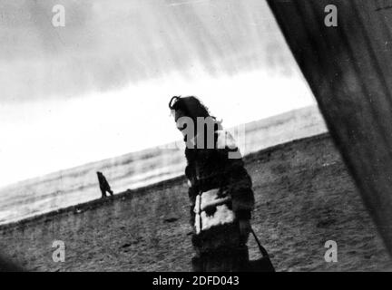 1960s 1970s Outdoor Meer junge Frau in schwarz und weiß allein am toskanischen Strand von Castinglioncello. Italien. Scannen von Kratzern und Flecken Stockfoto