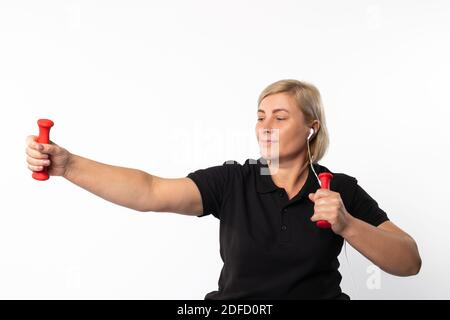 Fitness Frau zu Hause in Kopfhörer mit Hanteln. Foto auf weißem Hintergrund. Stockfoto