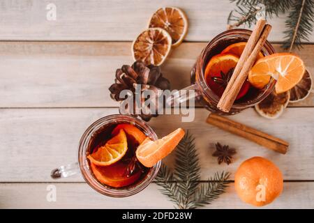 Heißer Glühwein mit Früchten und Gewürzen auf Holzgrund. Winter wärmende Getränk für den Urlaub. Stockfoto