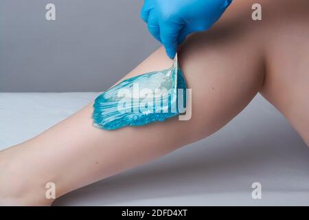 Das Verfahren shugaring Beine.die Anwendung von blauem Zucker paste.depilation in Der Salon Stockfoto
