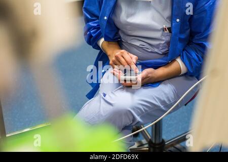 Krankenschwester mit einem Smartphone in einem Operationssaal, Frankreich. Stockfoto