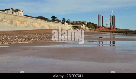 Die neue Ufermauer in Dawlish wurde 2020 angehoben und wieder aufgebaut, mit Blick auf den Bahnhof bei Ebbe. (Siehe Hinweis). Stockfoto