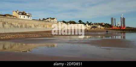 Die neue Ufermauer in Dawlish wurde 2020 angehoben und wieder aufgebaut, mit Blick auf den Bahnhof bei Ebbe. (Siehe Hinweis). Stockfoto