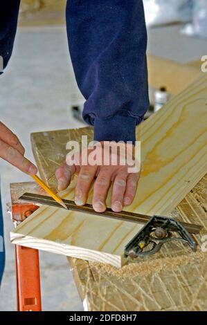 Zimmermann mit Hand quadratischen Werkzeug, um eine genaue Messung zu machen Stockfoto