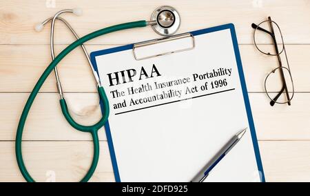 Schreibtisch, Notebook, Brille, Stift und Dokumente mit HIPAA der Health Insurance Portability and Accountability Act von 1996 auf die Überschrift Stockfoto