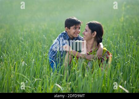 Glückliche Mutter und Sohn auf dem landwirtschaftlichen Feld Stockfoto