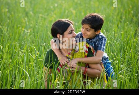 Glückliche Mutter und Sohn auf dem landwirtschaftlichen Feld Stockfoto