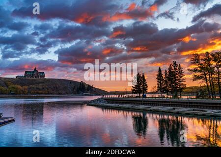 Waterton Lakes National Park Seeufer bei Sonnenaufgang in der Herbstlaubsaison. Blauer Himmel, wunderschöne feurige Wolken reflektieren wie ein Spiegel auf der Wasseroberfläche des Sees. Stockfoto