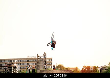 Kerl springen auf dem Fahrrad auf Pumptrack im Sommer oder Herbst im Freien bei Sonnenuntergang. Stockfoto