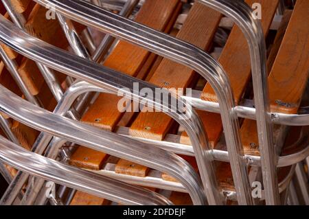 Nahaufnahme von Metallstühlen aus Holz in einem Stapel gestapelt. Stockfoto