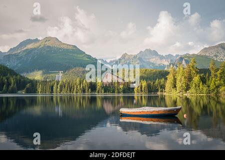 Bergsee Strbske Pleso mit kleinem Boot im Vordergrund im Nationalpark hohe Tatra. Slowakei, Europa. Spätsommerabend am Seeufer. Stockfoto