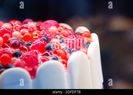 Weißer Kuchen mit cremiger Himbeere und Heidelbeere gekrönt Stockfoto