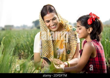 Ländliche Mutter und Tochter mit Handy auf dem landwirtschaftlichen Feld Stockfoto