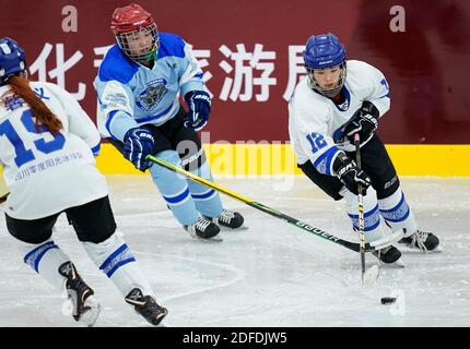 Tengchong, Chinas Provinz Yunnan. Dezember 2020. Xu Jiale (R) vom Sichuan-Team bewegt den Puck während des Weibergrundes EIN Spiel zwischen dem Sichuan-Team und dem Hulun buir-Team bei den nationalen Eishockey-Meisterschaften in Tengchong, südwestlich der chinesischen Provinz Yunnan, 4. Dezember 2020. Quelle: Wang Peng/Xinhua/Alamy Live News Stockfoto