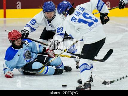 Tengchong, Chinas Provinz Yunnan. Dezember 2020. Li Yang (C) von Sichuan Team kämpft um den Puck während des Weibergrundes EIN Spiel zwischen Sichuan Team und Hulun buir Team bei der National Ice Hockey Championships in Tengchong, südwestlich Chinas Provinz Yunnan, 4. Dezember 2020. Quelle: Wang Peng/Xinhua/Alamy Live News Stockfoto