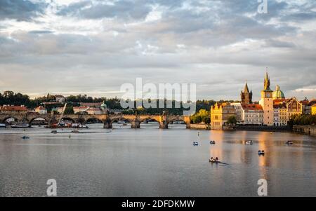 Prag und der Fluss Vlatava, Tschechische Republik. Stadtlandschaft der berühmten Wahrzeichen Karlsbrücke und Old Town Bridge Tower in der Dämmerung.