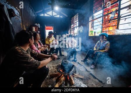 (201204) -- GONGSHAN, 4. Dezember 2020 (Xinhua) -- Kong Dangna (1. R) ruht mit ihrer Familie im Dorf Kongdang der Gemeinde Dulongjiang, Gongshan Dulong und Autonomen Kreis Nu, südwestlich der Provinz Yunnan in China, 31. Oktober 2020. Die 78-jährige Kong Dangna aus der Dulong-Ethnie erlebte einst Jahre mit ungenügender Nahrung und Kleidung und lebte von Brandrost-Anbau. In jenen Tagen dachte sie, das beste Leben sei, Buchweizennudeln für jede Mahlzeit zu essen. Dank der Hilfe der lokalen Regierung, Kongs Familie zog aus dem Berg in ein Gebiet in der Nähe des Dorfes comm Stockfoto