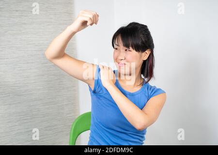 Asiatische Frau mit Schulterschmerzen Stockfoto