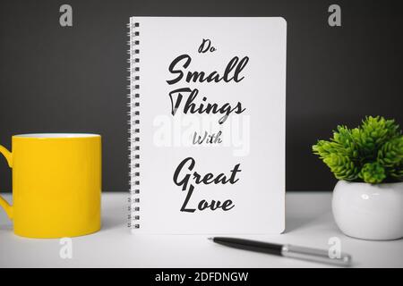 Motivierende und inspirierende Zitate. Tut Kleine Dinge Mit Großer Liebe. Stillleben des Notebooks auf dem Schreibtisch. Stockfoto