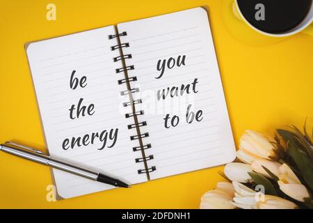 Motivierende und inspirierende Zitate. Sei Die Energie, Die Du Sein Möchtest. Stillleben des Notebooks auf dem Schreibtisch. Stockfoto