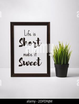 Motivierende und inspirierende Zitate. Das Leben ist kurz Machen Sie es süß. Still Life von Word Frame auf dem Schreibtisch. Stockfoto