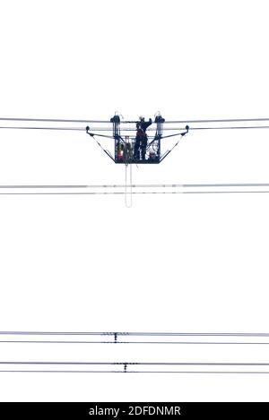 Elektrische Gondel mit Mann bei der Arbeit auf Hochspannungs-Leistung Kabel Stockfoto