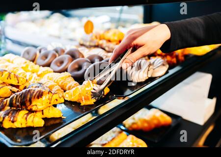 Weibliche Bäckerin serviert frische Kuchen Stockfoto