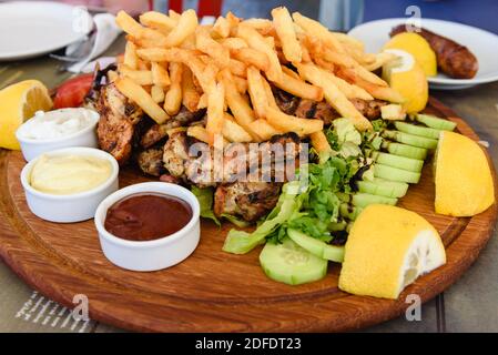 Traditionelle griechische Huhn und Schweinefleisch Souvlaki serviert mit Pommes in der griechischen Taverne. Stockfoto