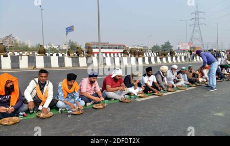 (201204) -- NEU-DELHI, 4. Dezember 2020 (Xinhua) -- Indische Bauern essen zu Mittag bei einer Überführung an der Grenze zwischen Neu-Delhi und Uttar Pradesh am 9. Tag des Protests gegen die neuen Agrargesetze am 4. Dezember 2020. (Xinhua/Partha Sarkar) Stockfoto