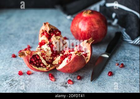 Nahaufnahme von reifen Granatapfelfrüchten und Samen auf Zementtheke. Stockfoto
