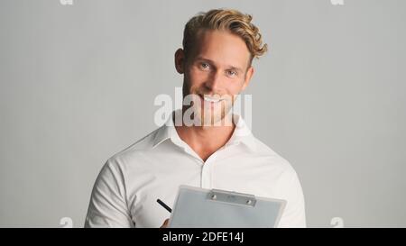 Attraktive bärtige Geschäftsmann im Hemd suchen glücklich mit Dokumenten isoliert auf weißem Hintergrund arbeiten. Erfolgreicher Mann Stockfoto