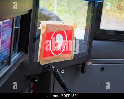 Budapest, Ungarn - 2. November 2020: Rote Farbmaske obligatorisch tragen Ikone geklebt an der Kabine Fenster in einem öffentlichen Bus in Budapest, Ungarn Stockfoto