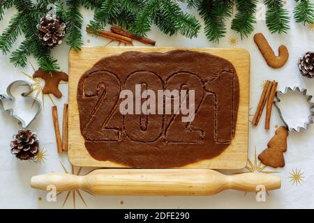 Lebkuchenfiguren. 2021 Beschriftung. Blick von oben. Layout des neuen Jahres. Neujahrsschrift zwischen Tannen und Keksen Stockfoto
