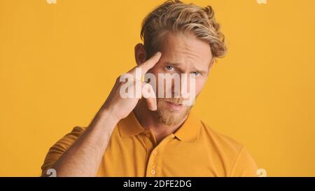 Schöner cooler bärtiger Mann zeigt selbstbewusst bis später Kamera über farbigem Hintergrund Stockfoto