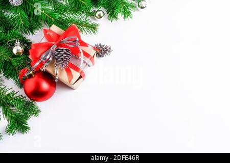 Weihnachten dekorierte Geschenkbox und silberne Kiefernzapfen, kopieren Raum. Weihnachtlicher Hintergrund mit roten und silbernen Ornamenten. Speicherplatz kopieren. Stockfoto