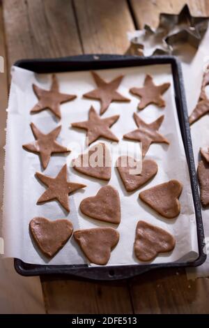 Rohe Lebkuchen schneiden Sterne, Herzen auf Backblech aus Stockfoto