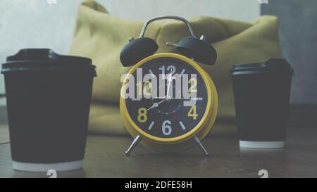 Cappuccino in Plastikgläsern mit Retro-Uhr, Hände von Stunden 8 Uhr, close-up. Duftenden Kaffee in Tassen. Stockfoto