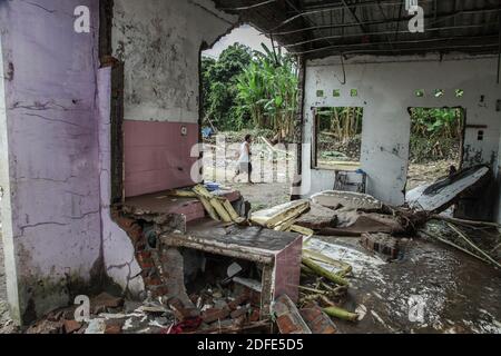 Medan, Nord-Sumatra, Indonesien. Dezember 2020. Ein Mann geht in der Nähe der Trümmer eines Hauses, das von Überschwemmungen als Folge des schnellen Flusses, der ihr Haus in Medan untergetaucht wurde, weggefegt wurde. Heftige Regenfälle überschwemmten Tausende von Häusern und ließen eine Reihe von Menschen tot und vermisst. Quelle: Albert Ivan Damanik/ZUMA Wire/Alamy Live News Stockfoto