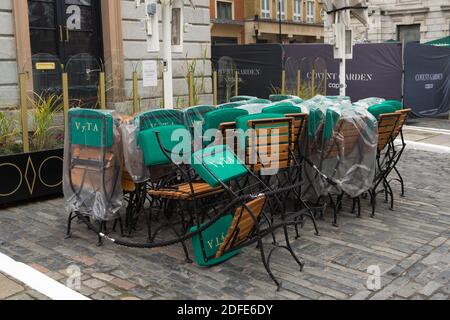 Gestapelte Stühle und Tische vor einem Restaurant in Covent Garden. London Stockfoto