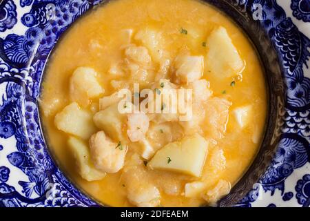 Draufsicht auf gekochten Kabeljau mit Garnelen, Kartoffeln und Petersilie auf einem dekorierten Teller. Kochen Rezepte mit Fisch und Gemüse. Gesunde Ernährung. Stockfoto