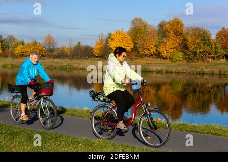 Zwei ältere Frauen radeln im Herbst entlang des Elbweges Stockfoto