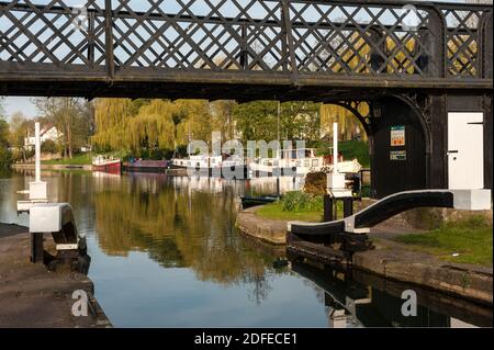CAMBRIDGE, Großbritannien - 24. APRIL 2010: Blick auf die Fußgängerbrücke bei Jesus Lock auf der River Cam mit Hausbooten im Hintergrund Stockfoto