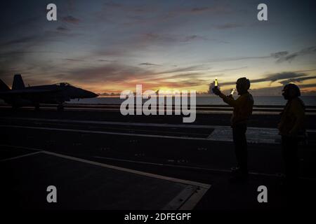 Handout Foto vom 1. Juli 2020 der Luftfahrt Boatswain's Mate (Handling) Airmen Devan Schaeffer, links, aus Duncan, Oklahoma, Und Samuel Owens aus Waco, Texas, signaliert ein Flugzeug auf dem Flugdeck des einzigen vorwärts eingesetzten Flugzeugträgers der Marine USS Ronald Reagan (CVN 76) und sorgt so für einen sicheren und konsistenten Flugbetrieb auf See. Zwei US-Flugzeugträger haben Bohrarbeiten im Südchinesischen Meer durchgeführt, sagte ein Sprecher der US-Marine am Samstag, nachdem das Pentagon seine Besorgnis über die chinesischen Militärübungen um einen umstrittenen Archipel zum Ausdruck gebracht hatte. Die USS Nimitz und USS Ronald Reagan führten duale Ca Stockfoto