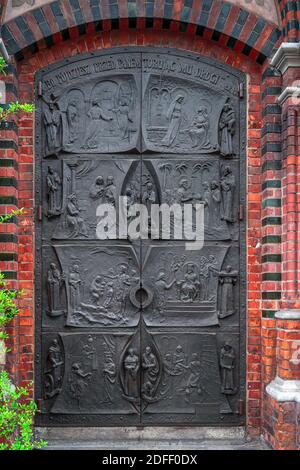 Szczecin, Polen, Juni 2019 verzierte Eisentür einer kleinen Basilika, römisch-katholische Pfarrei St. Johannes der Täufer, gegründet 1888 Stockfoto