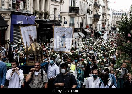 Die Prozession der Pilger auf der Straße M de Marie geht in der Straße von Paris, um die Basilika Sacré Coeur in Montmartre zu erreichen, mit weißen Rosen und nach einem Statut der Jungfrau Maria mit ihrem Kind am Tag der Himmelfahrt, eine katholische und orthodoxe Feier. Paris, Frankreich 15. August 2020. Foto von Daniel Derajinski/ABACAPRESS.COM Stockfoto