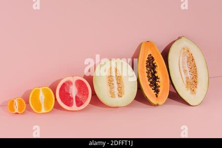 Kreatives Layout mit sommerlichen exotischen Früchten. Hintergrund in rosa Farben. Lebensmittelkonzept, horizontale Ausrichtung mit Platz für Text. Stockfoto