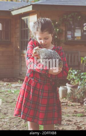 Kleines Mädchen in roten Tartan Kleid mit cremefarbenen crested Beinschiene Hahn Stockfoto