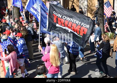 Washington DC. November 2020. Million Maga März. Menschen mit der Flagge „Waffenbesitzer für Trump“, der amerikanischen Flagge und der Flagge Trump 2020 auf dem Freedom Plaza. Stockfoto